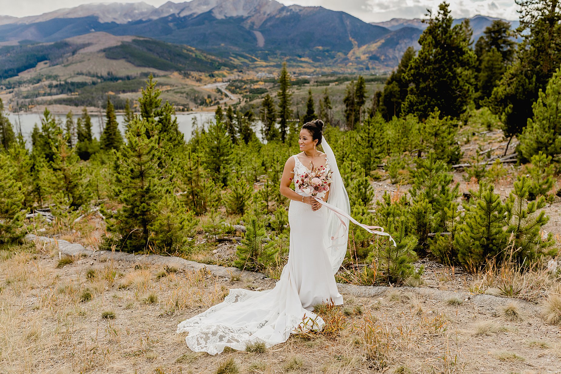 Bride holds bouquet in front of beautiful mountain views of Sapphire Point before her elopement ceremony