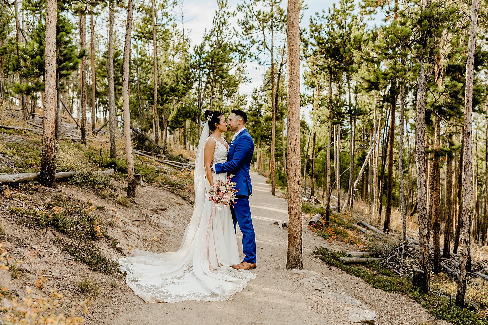 Bride and groom stand in a beautiful forest before their sapphire point elopement ceremony