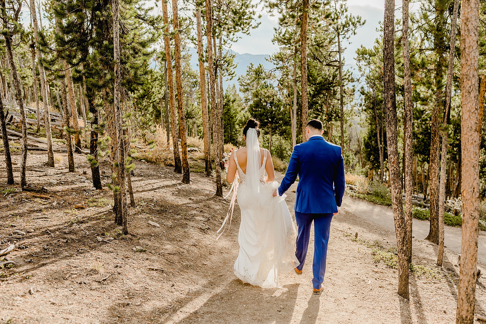 Couple hikes through forest in breckenridge colorado for their elopement