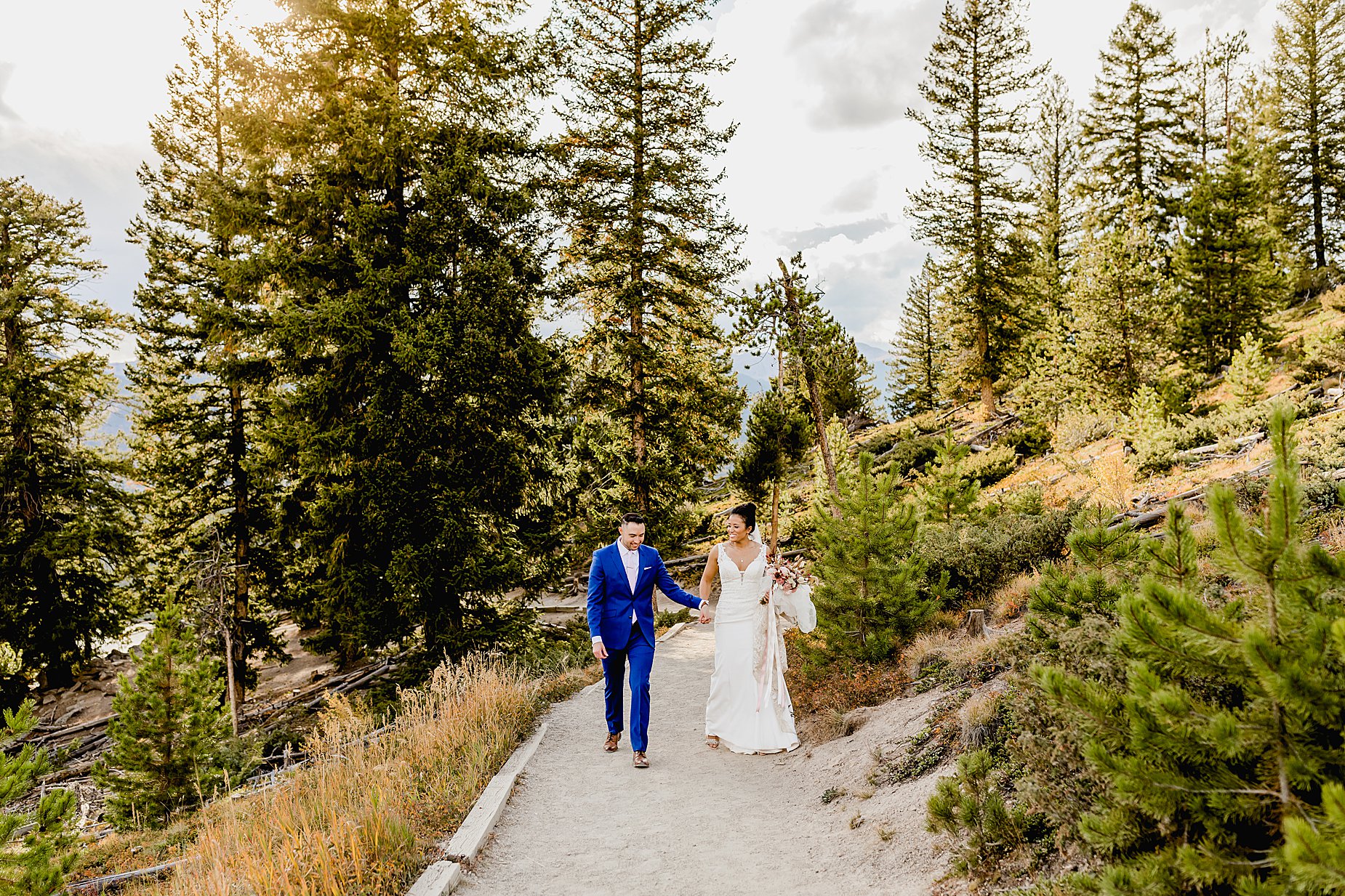 Couple hikes through forest in breckenridge colorado for their fall elopement