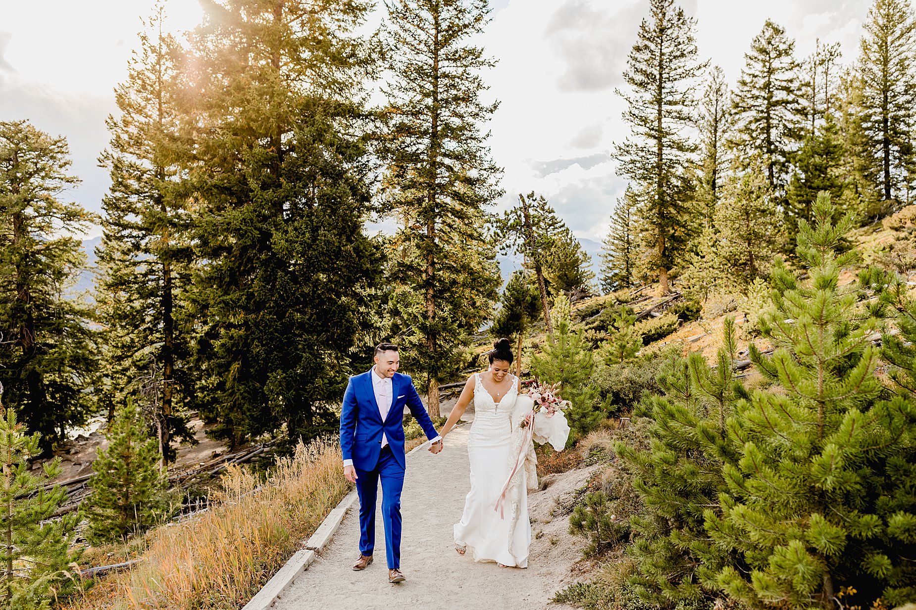 Couple hikes through forest in breckenridge colorado for their fall elopement