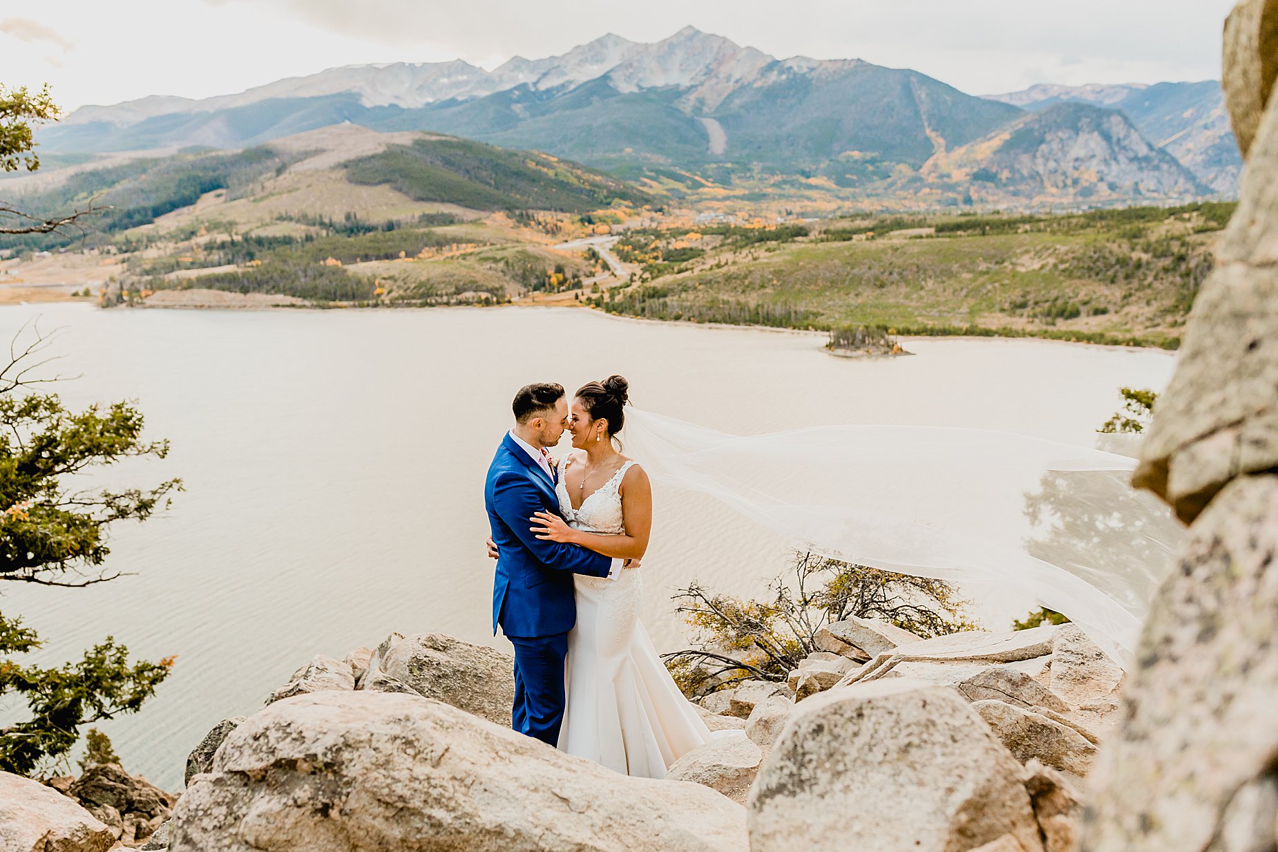 Bride and groom stand on rocks for their breckenridge fall elopement at sapphire point colorado