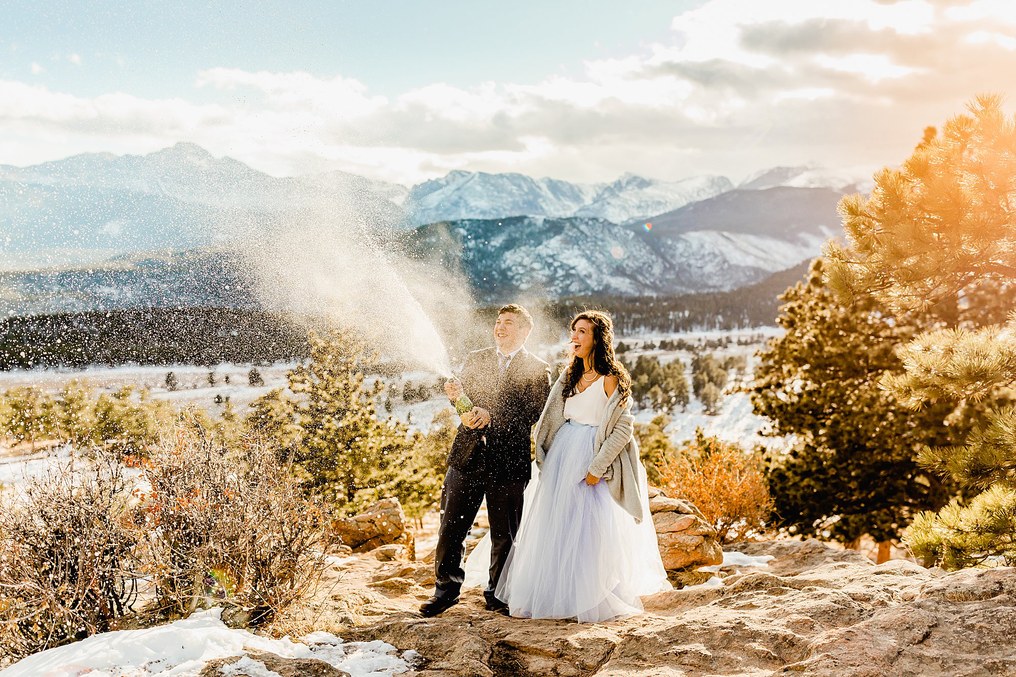 bride and groom pop champagne to celebrate their Colorado elopement with beautiful mountain views