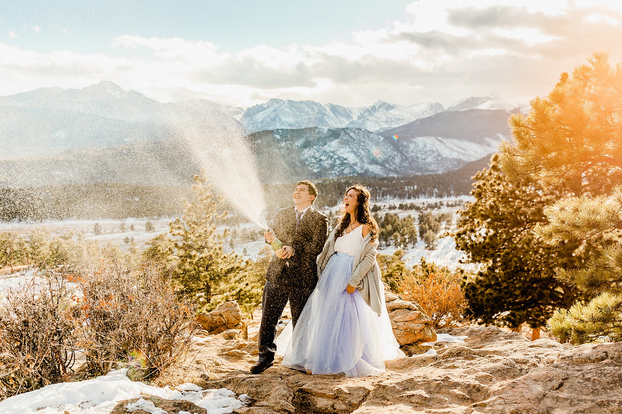 bride and groom pop champagne to celebrate their Colorado elopement with beautiful mountain views