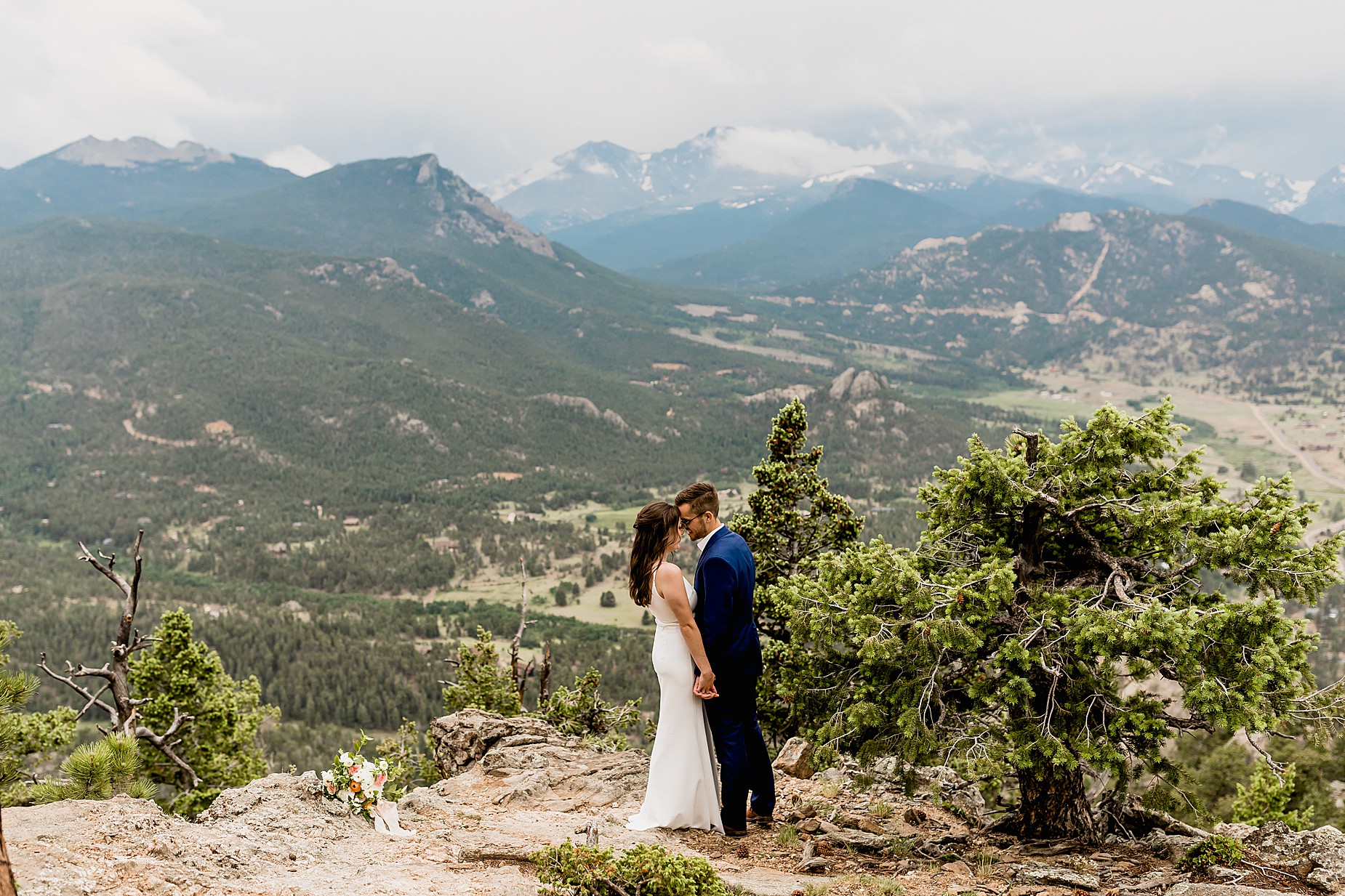 Couple spends their hiking elopement together with gorgeous Colorado Rocky Mountain Views in the background on a moody day
