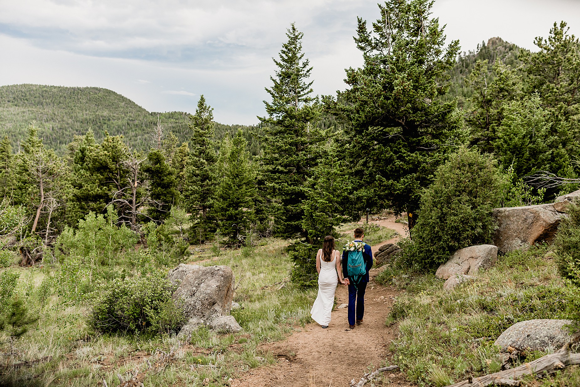 Bride and groom walk through the aspens for their Estes Park hiking elopement