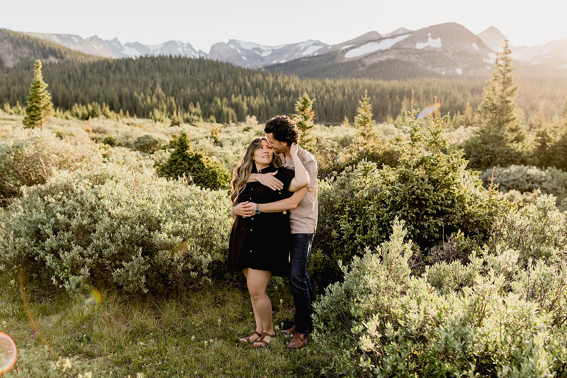 Couple takes Colorado anniversary photos in front of a beautiful mountain and alpine lake in the summer