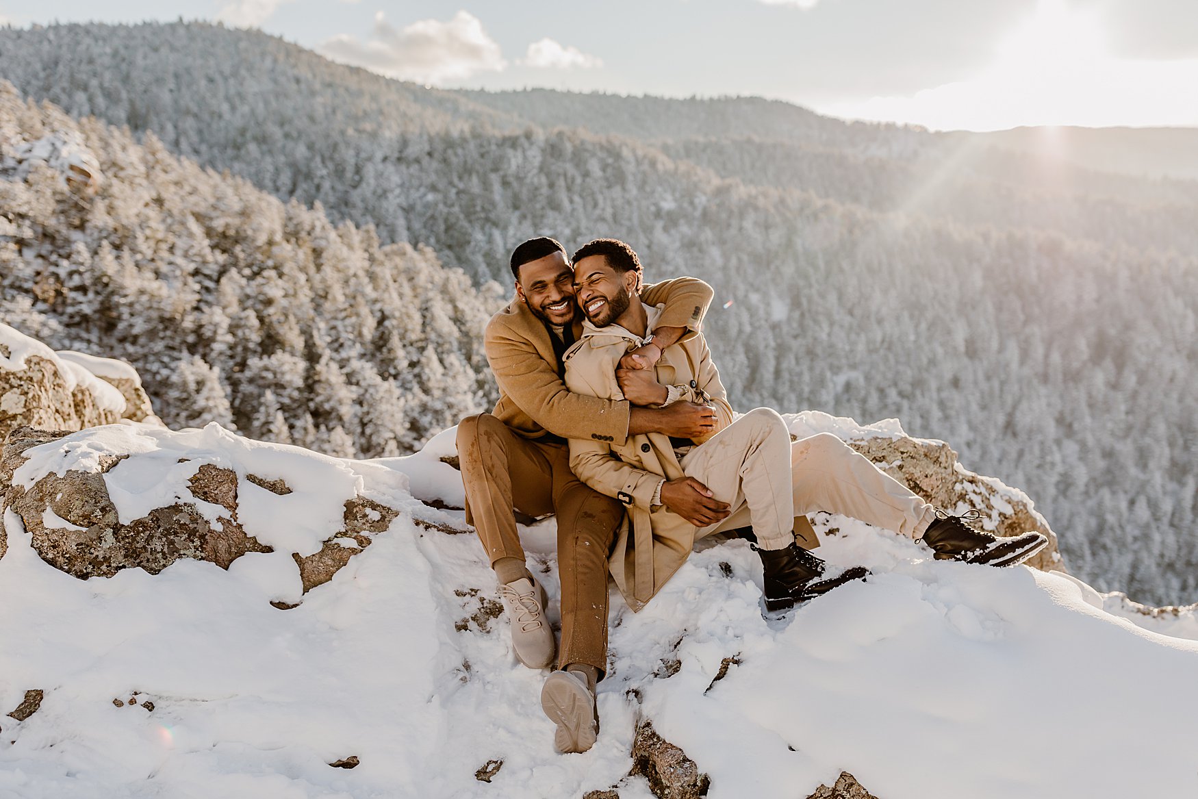 Couple laughs and embraces in the snowy mountains of Colorado for their winter engagement photos